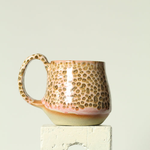 Ceramic mug with textured handle on a light gray background
