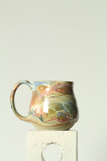 Ceramic mug with coral reef design on a plain background