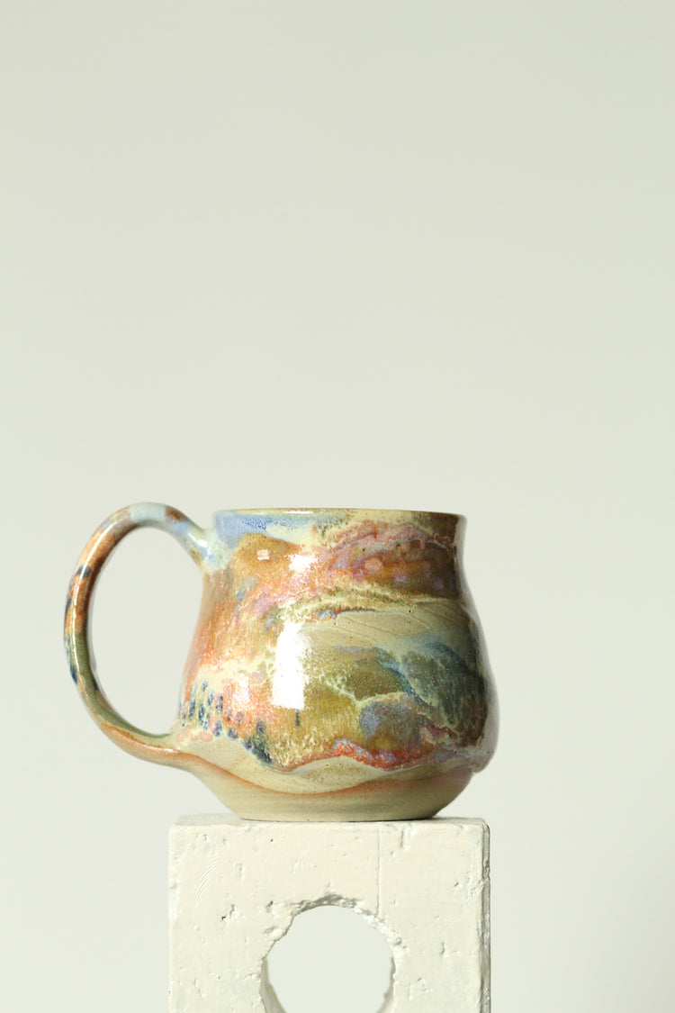 Ceramic mug with coral reef design on a plain background