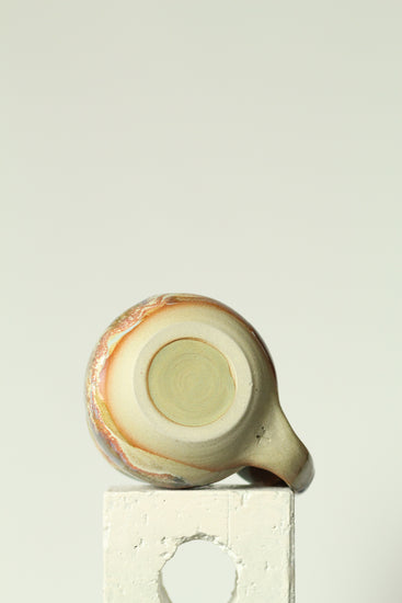 Ceramic mug base with a decorative pattern on a plain background