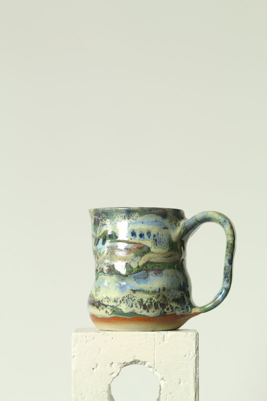 Handmade green stoneware ceramic mug with carved thumb rest and pressed thumb impression, made in Australia
