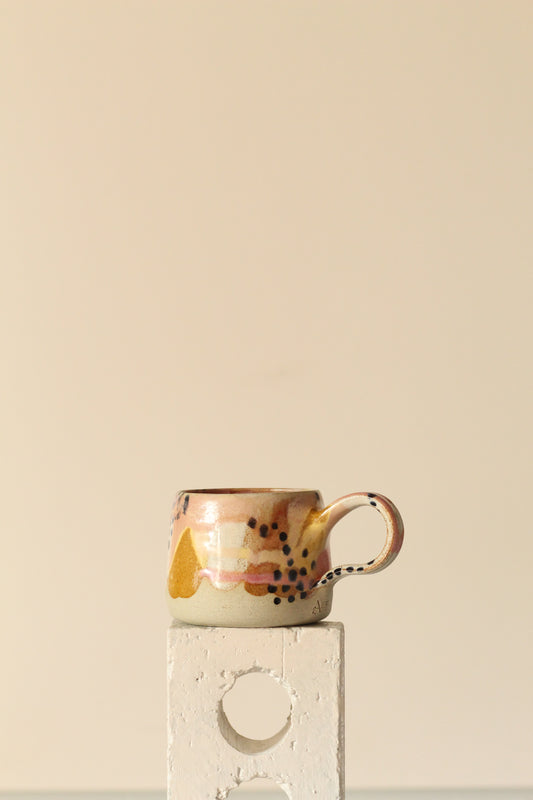 Pink, white, yellow, beige and black dotted mug