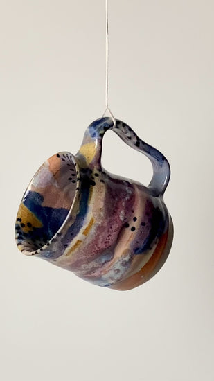 Handmade ceramic mug in the Body form with Imprint handle detail, finished in painterly Dusk glaze with layered blues, violet and warm clay tones. spinning to see full mug